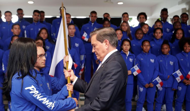 Kristine Jiménez y Héctor Cención recibieron ayer el pabellón de manos del presidente Laurentino Cortizo. EFE