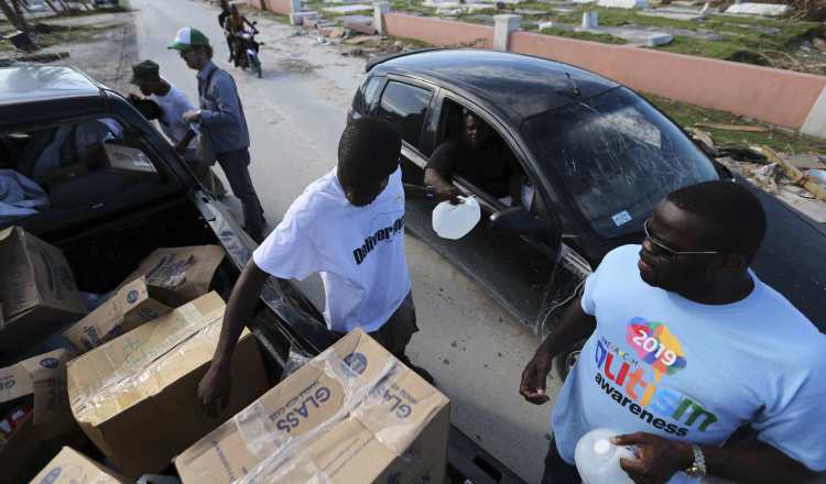 Voluntarios entregan agua y alimentos a los sobrevivientes del huracán Dorian en Bahamas. AP