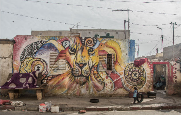 Las paredes de un barrio de Dakar se han transformado en un museo al aire libre, atrayendo a turistas. Foto/ Yagazie Emezi.