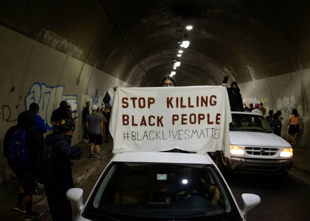 Una manifestante confronta a la Policía en Kenosha (EE.UU.), en la continuación de las protestas por el ataque policial contra Jacob Blake. Fotos. EFE.