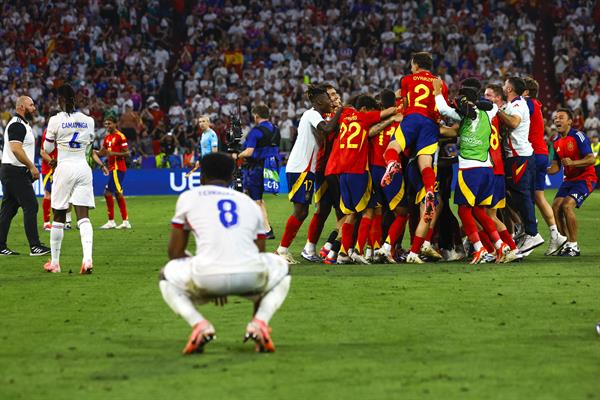 Jugadores de España festejan su pase a la semifinal de la Eurocopa, los de Francia se lamentan. Foto: EFE