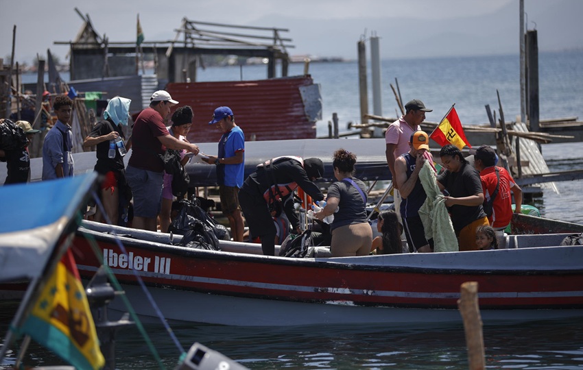 Migrantes venezolanos se suben a una embarcación en la isla Gardi Sugdub con destino a Colombia.  Foto: EFE/ Bienvenido Velasco