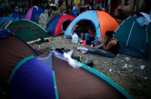 Personas migrantes descansan tras caminar días por la selva del Darién (Panamá)